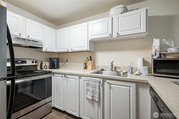 a kitchen with stainless steel appliances granite countertop a sink stove and cabinets