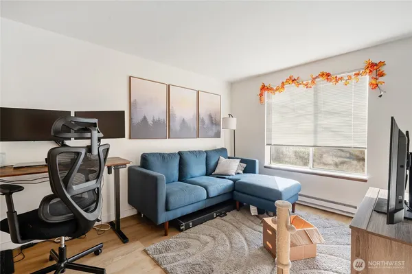 a living room with furniture a flat screen tv and a window
