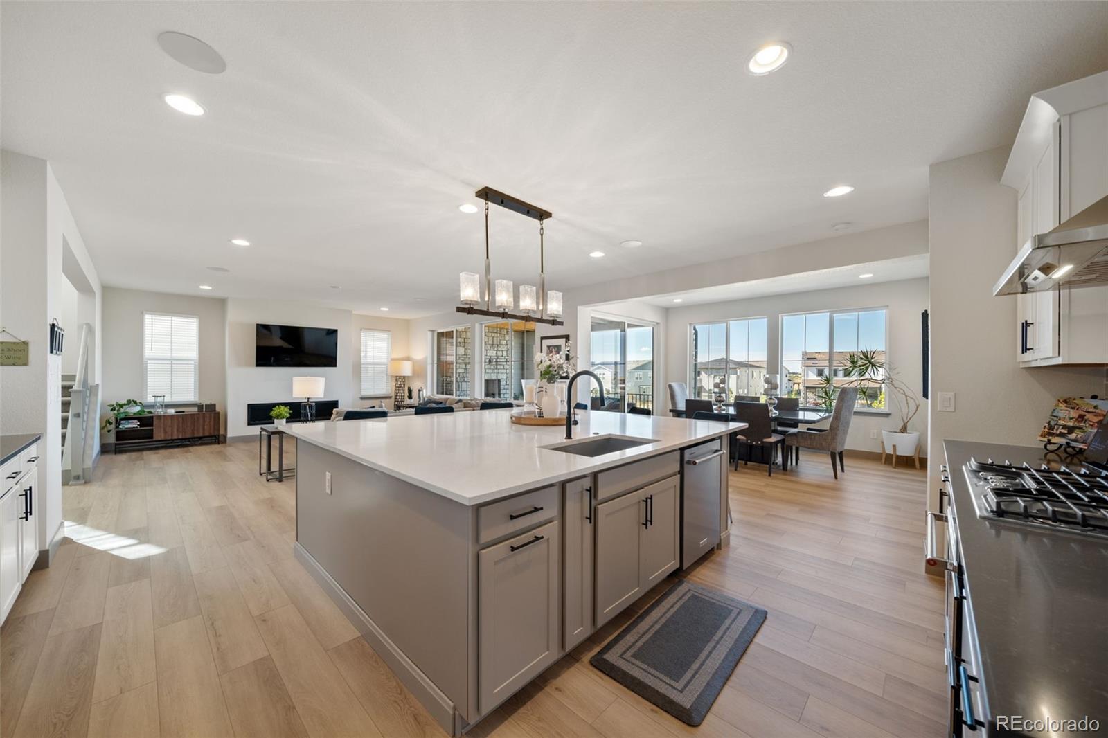 6465 Barnstead Drive Castle Pines, CO 80108 - Photo 11 of 50 a large kitchen with lots of counter space a sink appliances and living room view