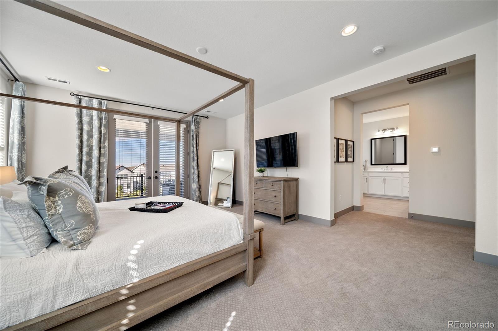 6465 Barnstead Drive Castle Pines, CO 80108 - Photo 18 of 50 a bedroom with a bed and a flat screen tv