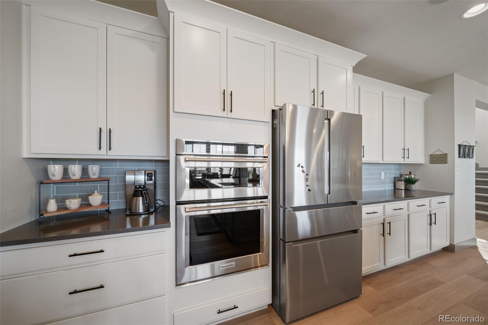 6465 Barnstead Drive Castle Pines, CO 80108 - Photo 9 of 50 a kitchen with stainless steel appliances white cabinets and a refrigerator