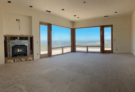 a view of an empty room with a fireplace and a window