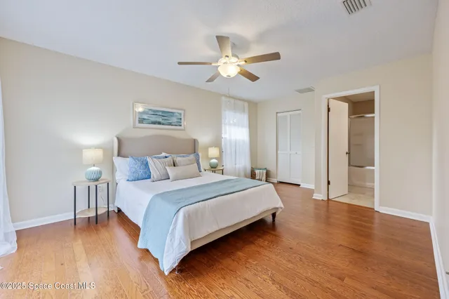 a bedroom with a large bed and wooden floor
