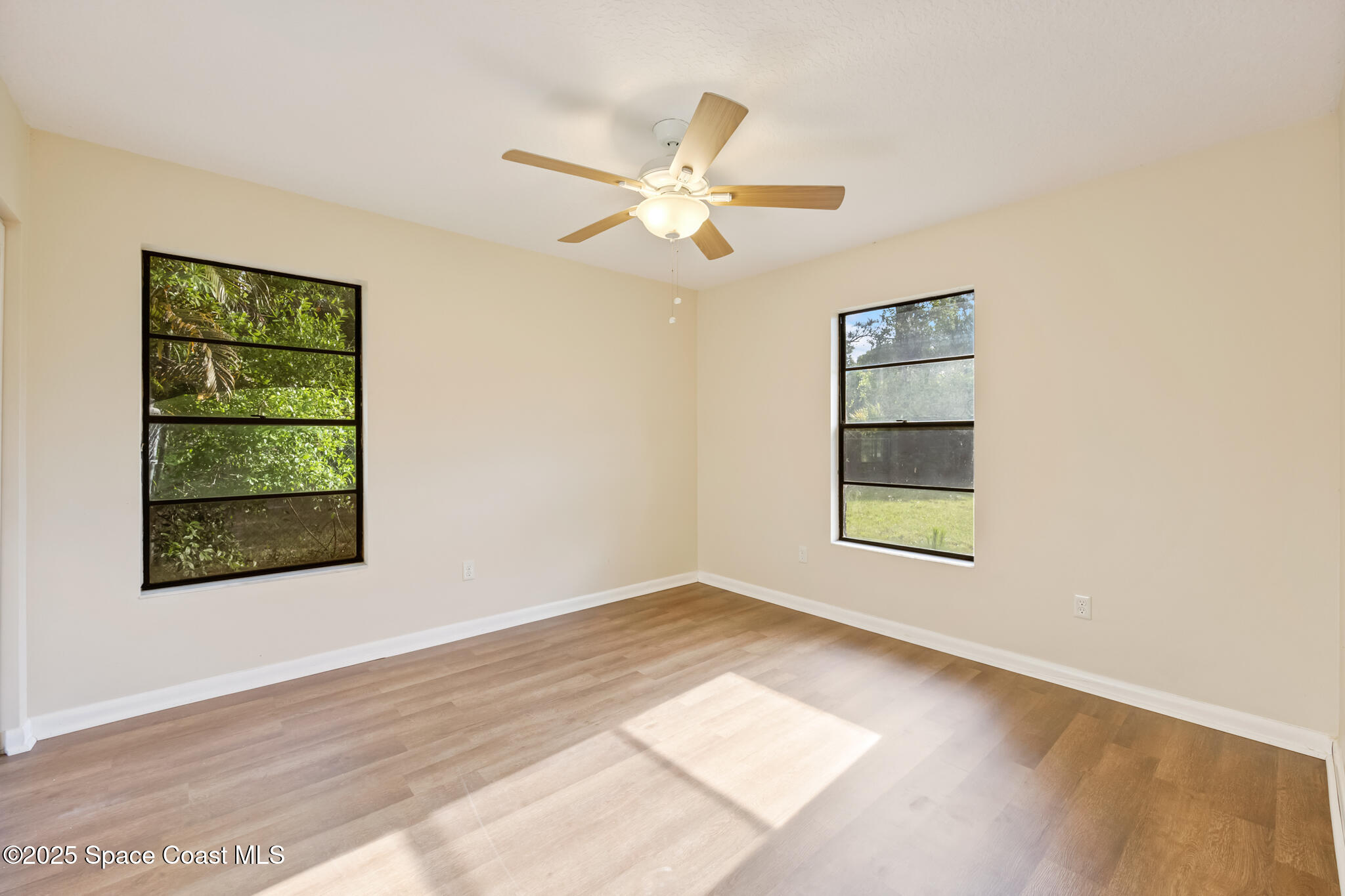 286 Alegriano Road Northwest Palm Bay, FL 32907 - Photo 18 of 24 an empty room with windows and fan