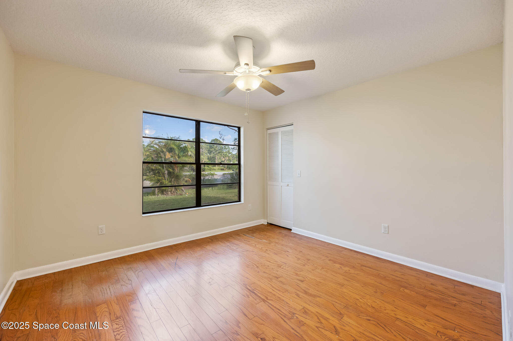 286 Alegriano Road Northwest Palm Bay, FL 32907 - Photo 20 of 24 wooden floor in an empty room with a window
