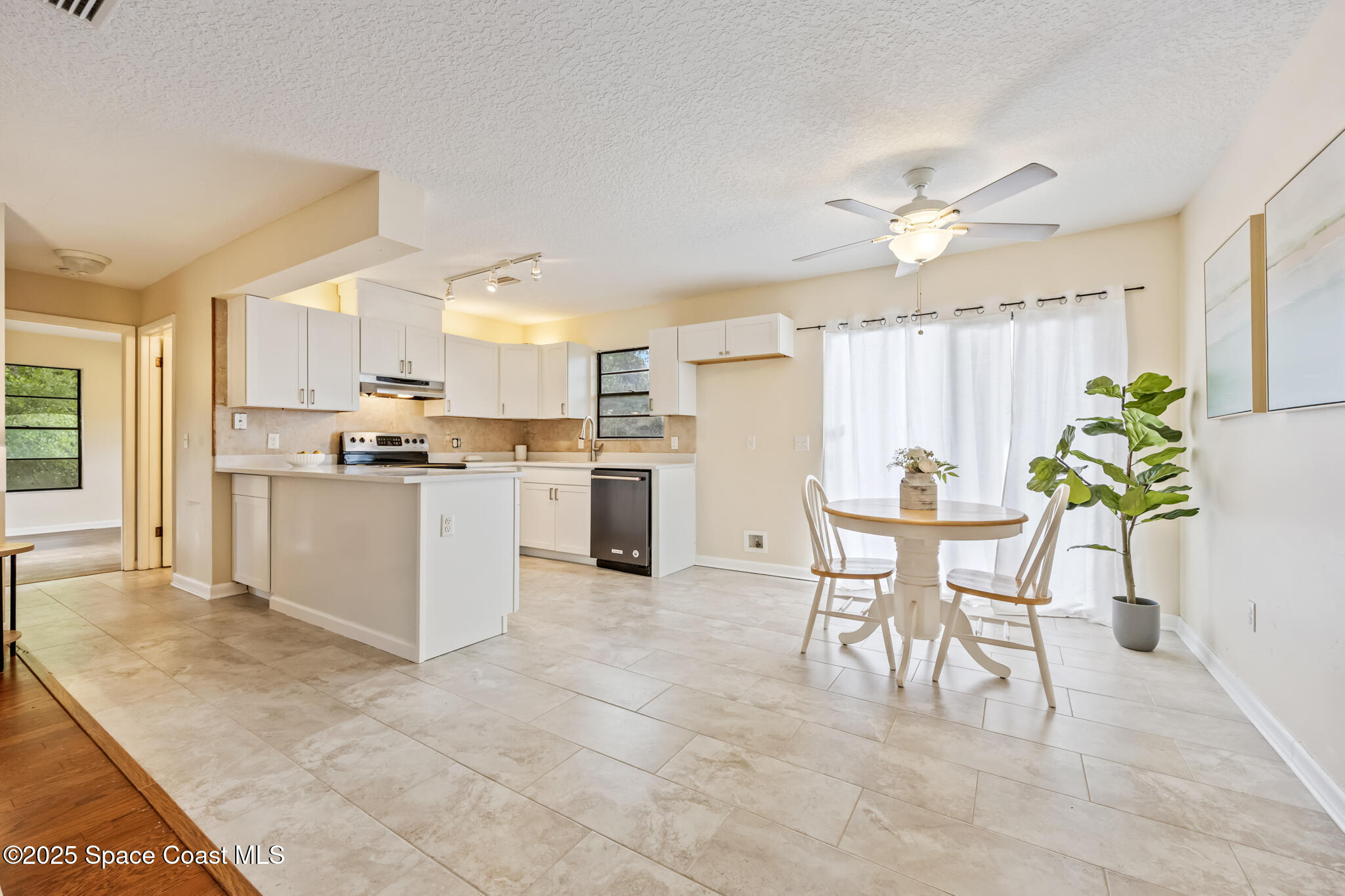 286 Alegriano Road Northwest Palm Bay, FL 32907 - Photo 7 of 24 a kitchen with granite countertop stainless steel appliances a table and chairs in it