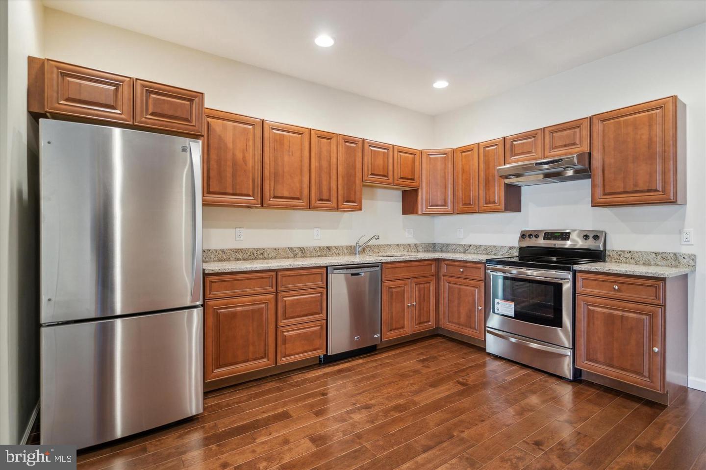 118 Richmond Street, Unit 2B Philadelphia, PA 19125 - Photo 3 of 14 a kitchen with granite countertop stainless steel appliances and wooden cabinets
