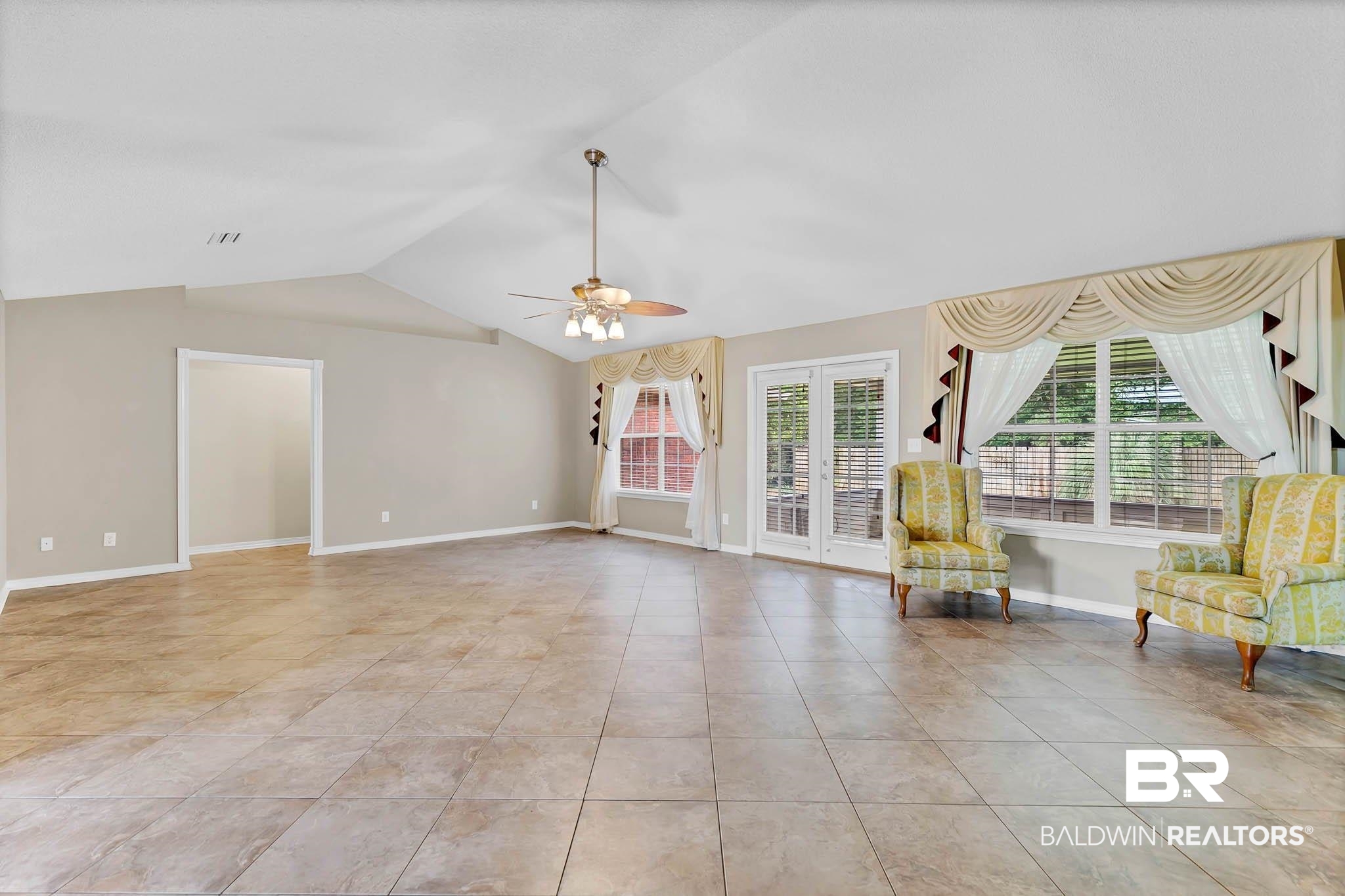 329 Collinwood Loop Foley, AL 36535 - Photo 5 of 35 Unfurnished room featuring lofted ceiling, light tile patterned flooring, a ceiling fan, baseboards, and french doors