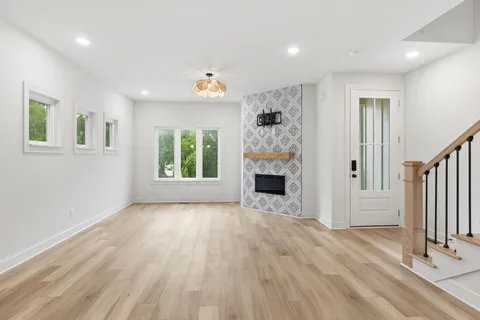 a view of an empty room with a window and fireplace