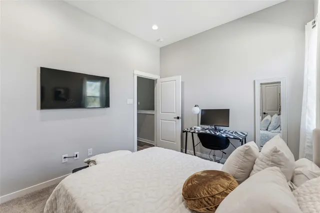 a bedroom with a bed flat screen tv and a couch