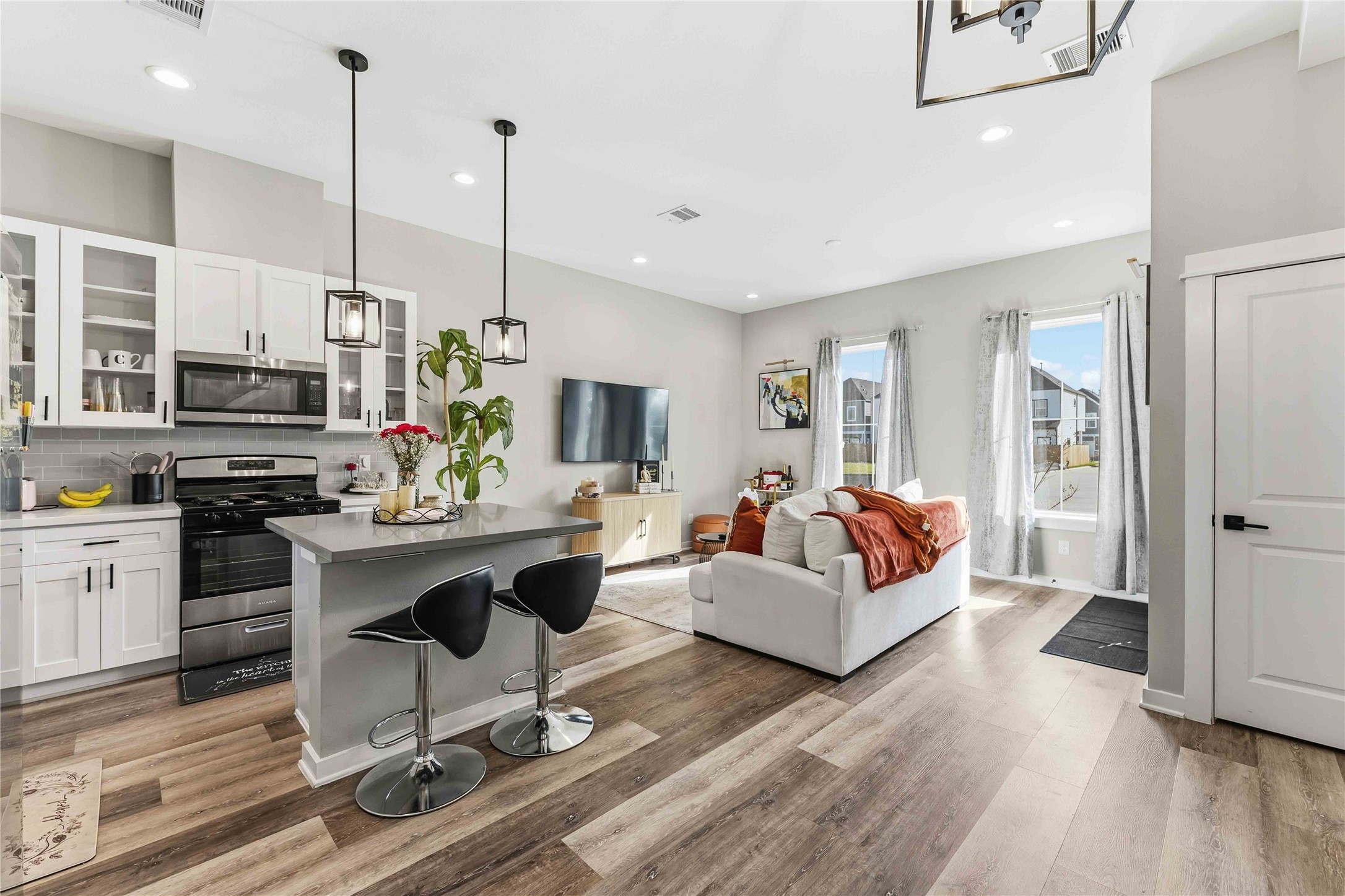 405 Stonework Garden Lane Houston, TX 77076 - Photo 5 of 23 a living room with furniture a fireplace kitchen view and a flat screen tv