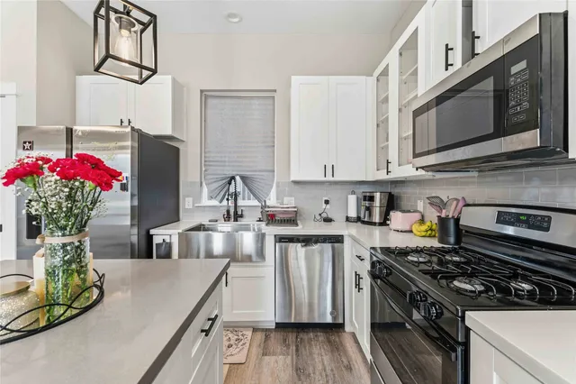 a kitchen with stainless steel appliances granite countertop a sink stove and microwave