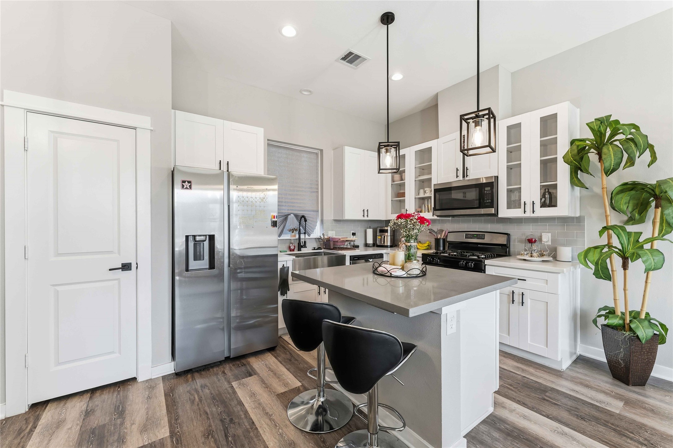 405 Stonework Garden Lane Houston, TX 77076 - Photo 9 of 23 a kitchen with stainless steel appliances granite countertop a refrigerator a stove a sink dishwasher and white cabinets with wooden floor