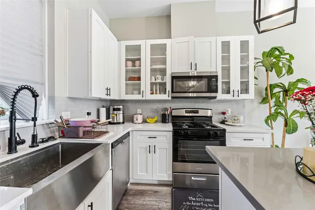 a kitchen with stainless steel appliances granite countertop a stove a sink and a microwave