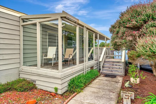 a view of a balcony with floor to ceiling windows and wooden fence