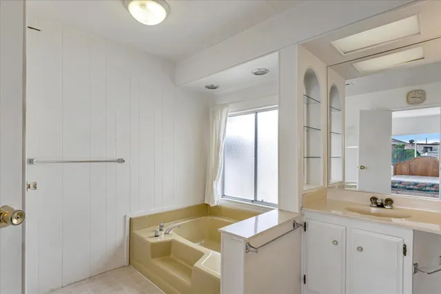a bathroom with mirror sink and window