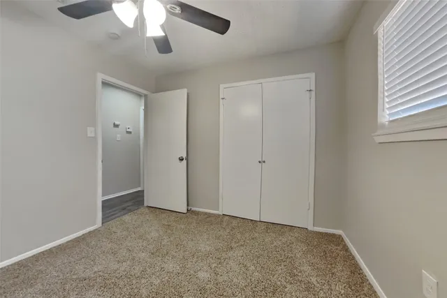 a view of an empty room and chandelier fan