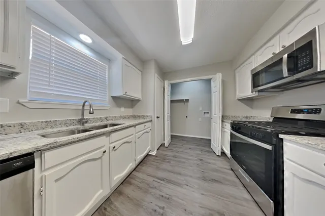 a kitchen with stainless steel appliances granite countertop a sink and stove top oven