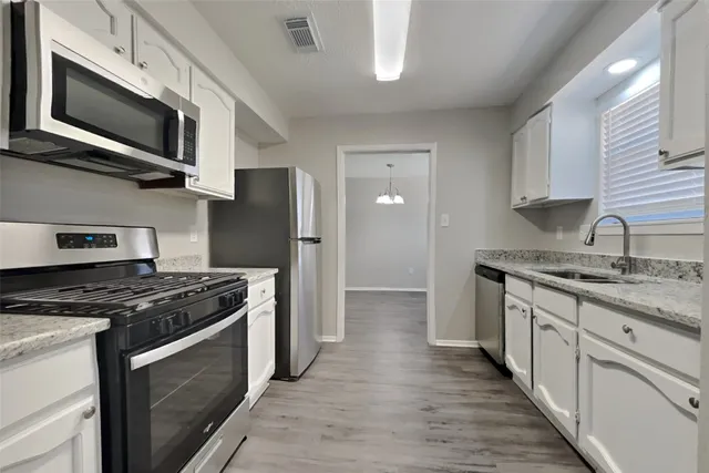 a kitchen with stainless steel appliances granite countertop a stove microwave sink and refrigerator