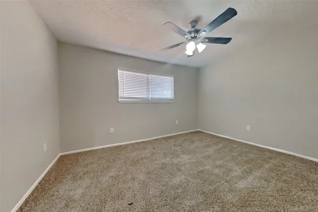 an empty room with closet and ceiling fan