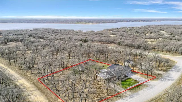 an aerial view of residential houses with outdoor space and trees