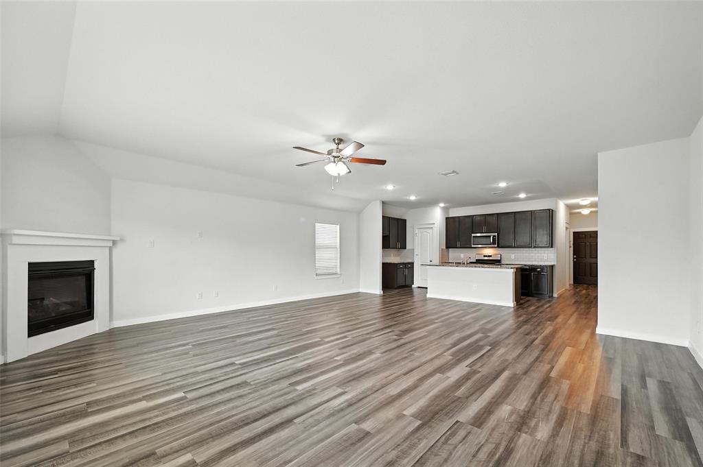 5019 Flanagan Drive Forney, TX 75126 - Photo 4 of 19 a view of empty room with wooden floor and fireplace