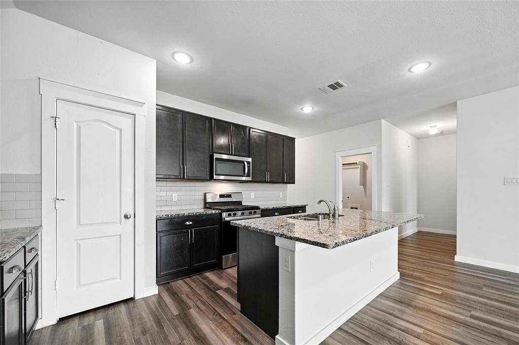 5019 Flanagan Drive Forney, TX 75126 - Photo 6 of 19 a kitchen with stainless steel appliances granite countertop a sink stove and refrigerator