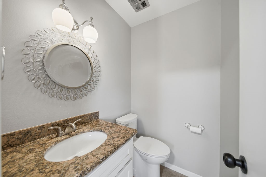 1408 Ramada Drive Houston, TX 77062 - Photo 11 of 28 a bathroom with a granite countertop toilet a sink and a mirror