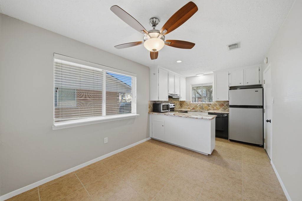 1408 Ramada Drive Houston, TX 77062 - Photo 13 of 28 a kitchen with a refrigerator and white cabinets