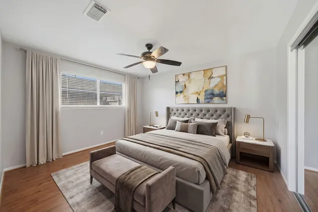 a bedroom with a bed ceiling fan and a window