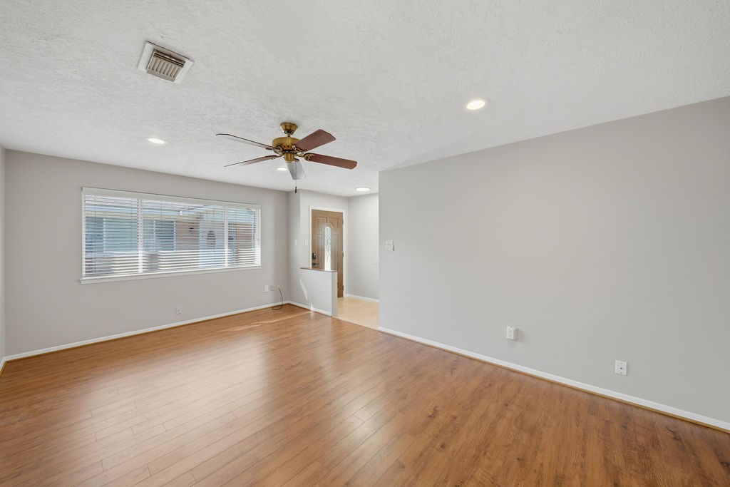 1408 Ramada Drive Houston, TX 77062 - Photo 7 of 28 a view of an empty room with a window and wooden floor