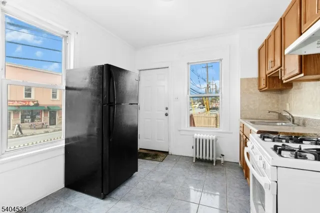 a kitchen with stainless steel appliances granite countertop a refrigerator and a stove top oven