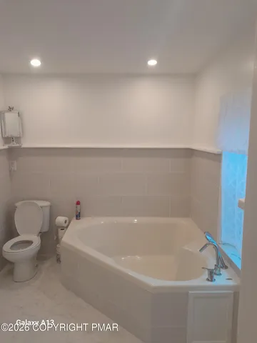 a white bath tub sitting next to a white toilet