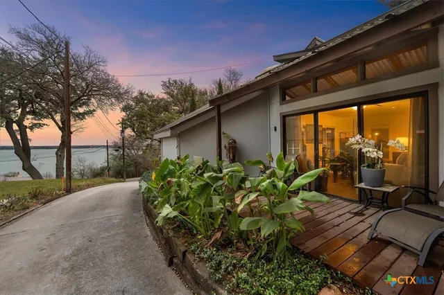 a backyard of a house with table and chairs under an umbrella