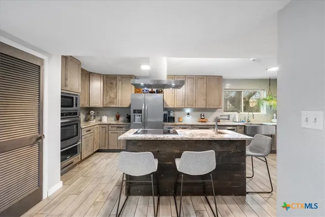 a kitchen with stainless steel appliances granite countertop a sink stove and refrigerator