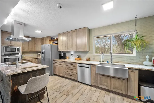 a large kitchen with a large counter top space appliances and cabinets