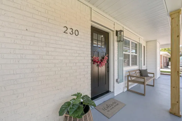 a living room with furniture kitchen view and a wooden floor