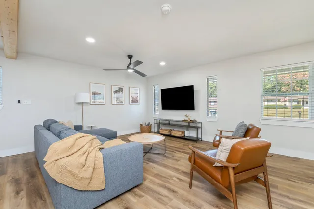 a living room with furniture and a view of kitchen