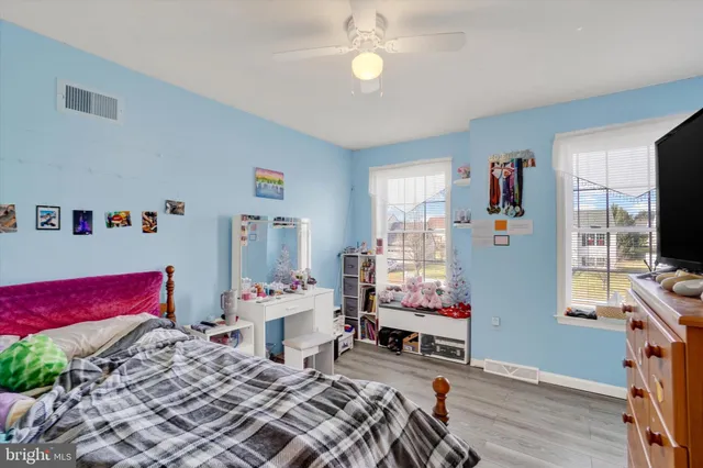 a bedroom that has a bed tv and a large window