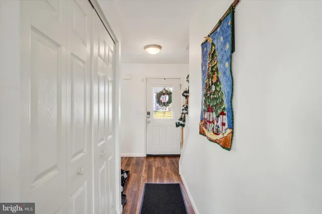 a view of a hallway with wooden floor and entryway