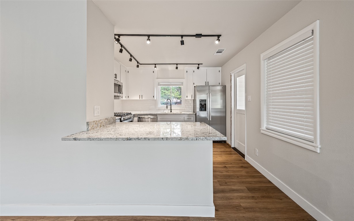 a view of a kitchen with a sink and wooden floor