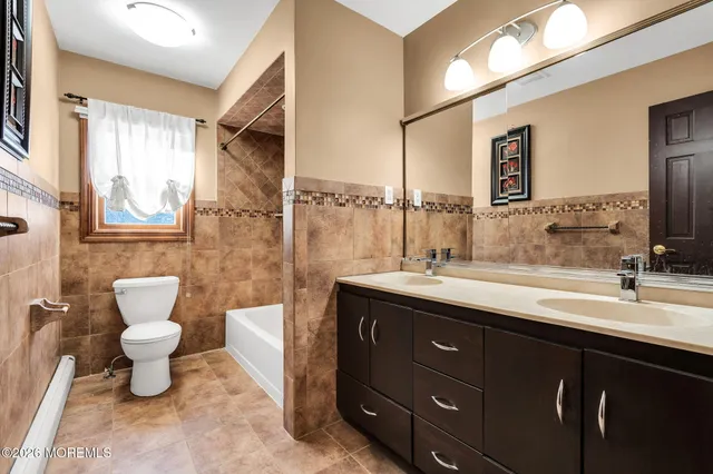a spacious bathroom with a toilet sink and mirror