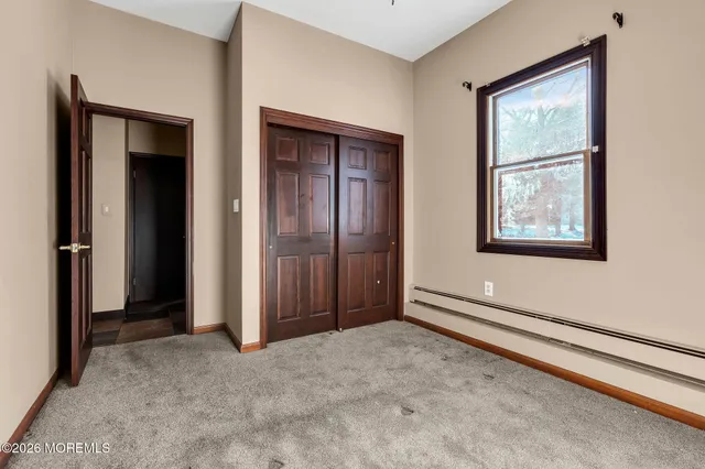 an empty room with windows and closet