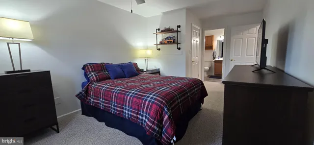 a bedroom with a bed and a flat tv screen on a dresser