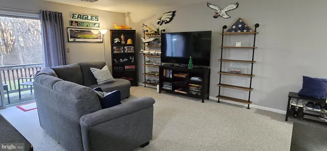 a living room with furniture a ceiling fan and a window