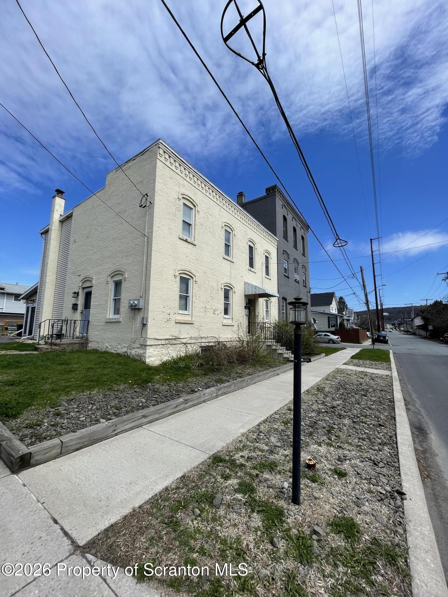 a view of a white house next to a yard