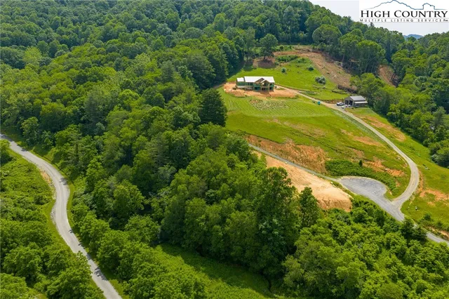 an aerial view of a house with a yard and lake view