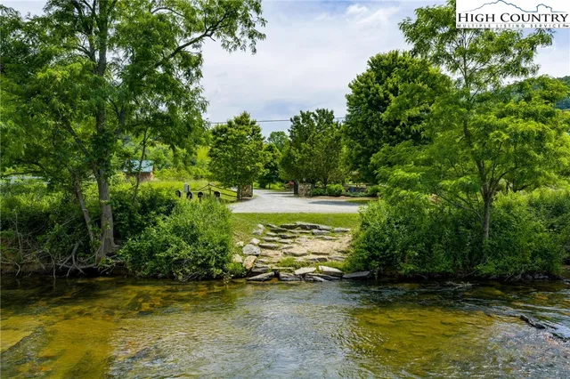 a view of a swimming pool with a patio and a yard