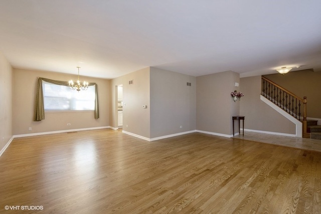 546 North Rohlwing Road Palatine, IL 60074 - Photo 2 of 17 a view of an empty room with wooden floor and a window