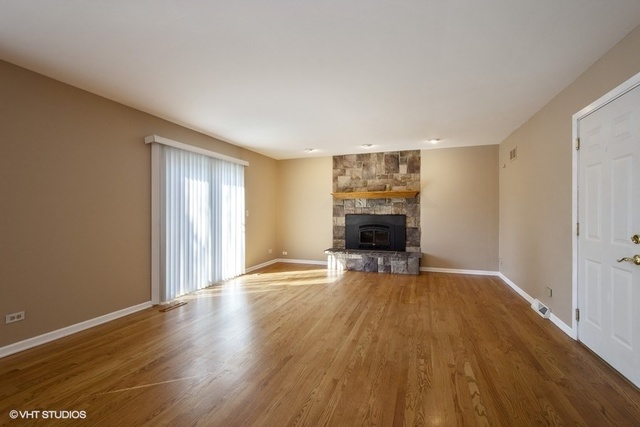 546 North Rohlwing Road Palatine, IL 60074 - Photo 5 of 17 a view of empty room with wooden floor and fireplace